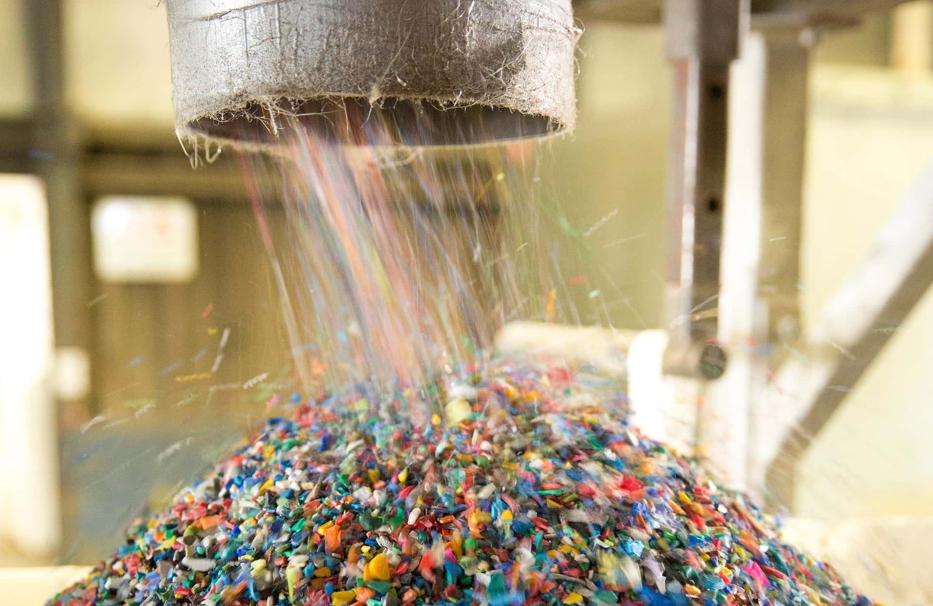 Een pijp waaruit kunststofgranulaat op een hoop wordt geblazen