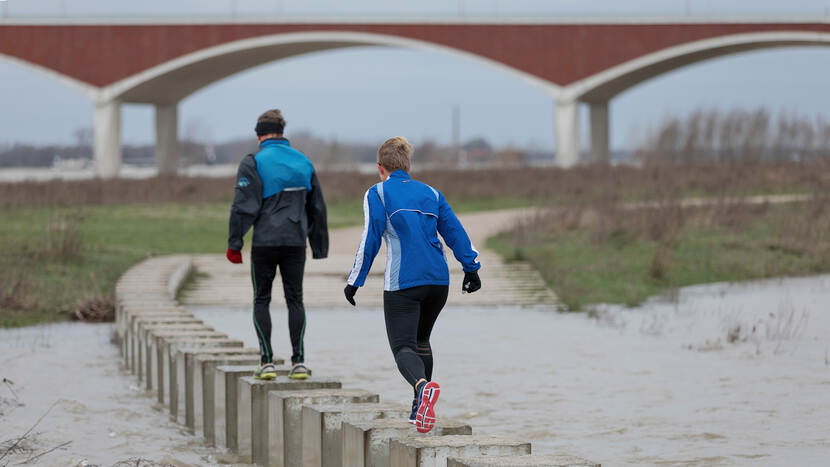 Foto van hardlopers bij Nijmegen tijdens hoogwater