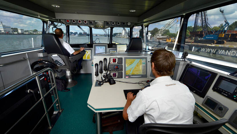 Gezagvoerder en waterinspecteur aan boord van patrouillevaartuig.