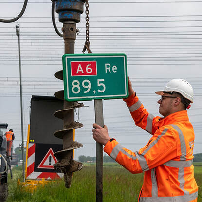 Foto plaatsing hectometerpaaltje op de A6 door Rijkswaterstaat medewerker